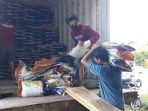 petugas-saat-menurunkan-beras-premium-di-gudang-sembako