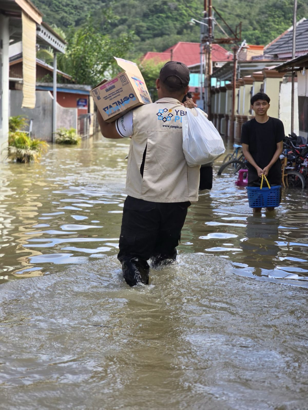 Relawan Yayasan Baitul Maal PLN (YBM PLN) PLN Unit Induk Distribusi Sulawesi Utara, Tengah, dan Gorontalo (UID Suluttenggo) menerjang lokasi terdampak banjir untuk menyalurkan bantuan kapada masyarakat yang terdampak